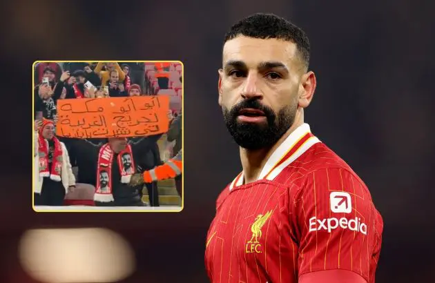 Mo Salah looks on during Liverpool v Spurs next to a picture of a fan holding a sign in Arabic.