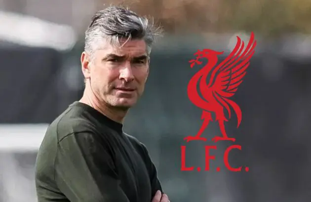 Richard Hughes looks at a training ground next to Liverpool club badge.
