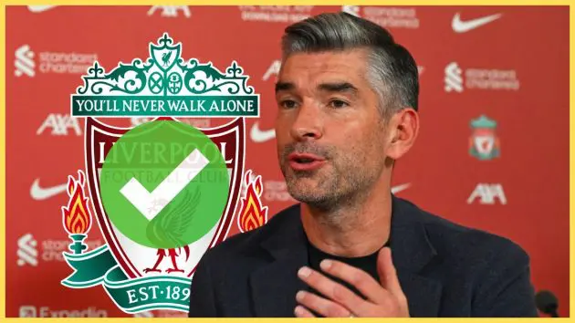 Richard Hughes gestures with his hand mid-speech next to Liverpool club crest.