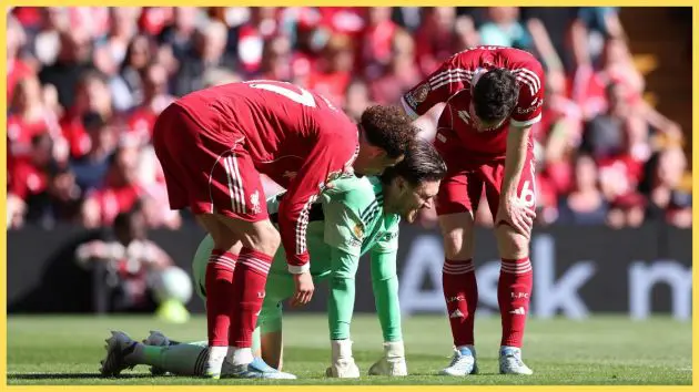 Freddie Woodman of Liverpool reacts with teammates Curtis Jones and Andrew Robertson after picking up an injury during the Premier League match between Liverpool and Crystal Palace at Anfield