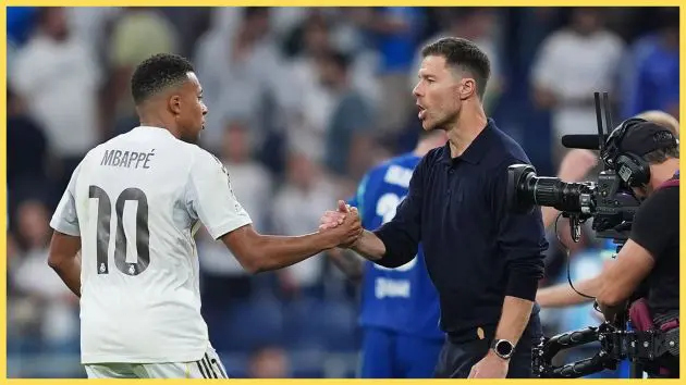 Xabi Alonso shakes hands with Real Madrid striker Kylian Mbappe.