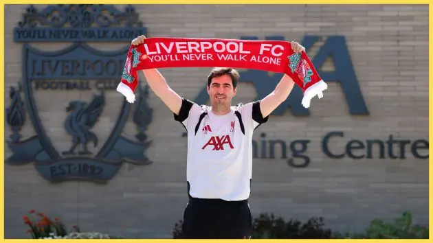 Liverpool manager Andoni Iraola holds up a red scarf.